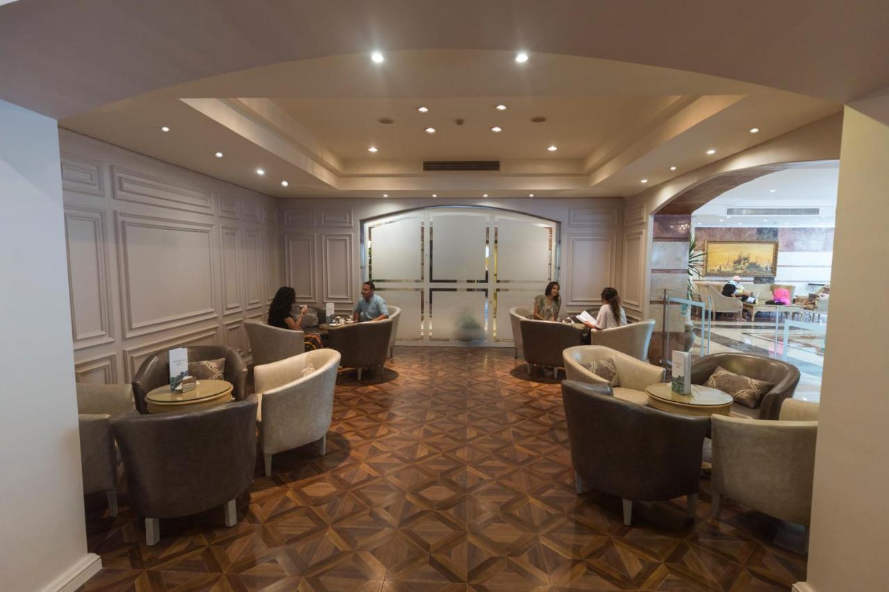 Sunrise Alex Avenue Hotel Alexandria Eksteriør bilde The photo shows a well-lit lounge area with a modern and elegant design. There are several comfortable seating arrangements, including plush chairs and small tables. The flooring appears to be made of a decorative wood pattern. In the background, the