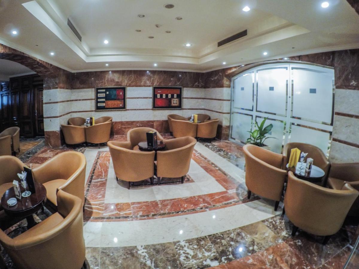 Sunrise Alex Avenue Hotel Alexandria Eksteriør bilde The photo depicts a stylish lounge area with several comfortable seating arrangements. There are plush, curved chairs arranged around small tables, likely intended for coffee or casual gatherings. The floor features a polished marble design, and the 